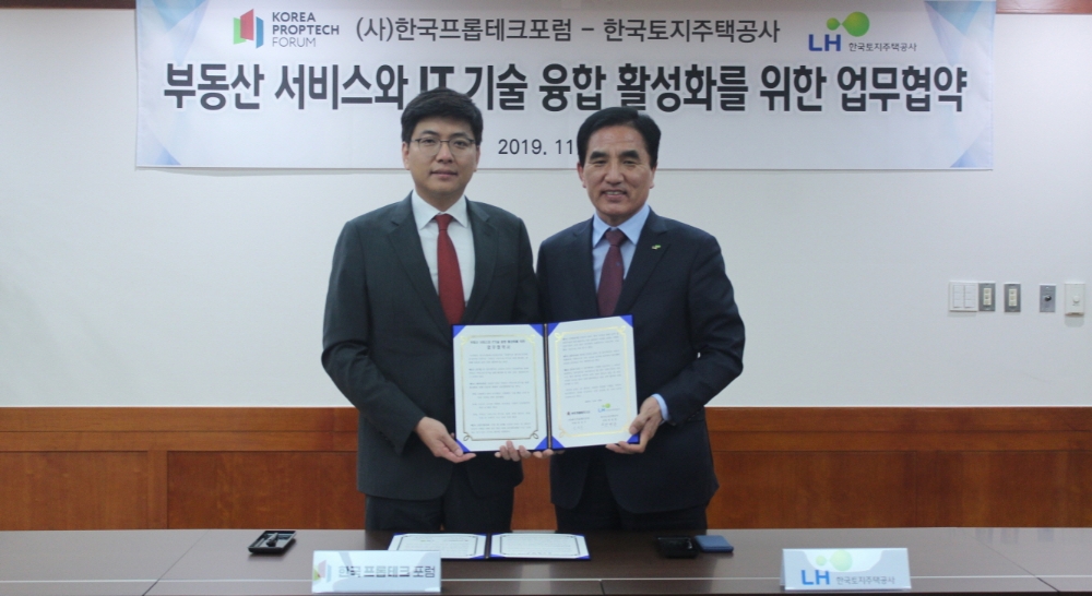 '부동산 서비스와 IT기술 융합 활성화를 위한 업무협약'을 체결한 한병홍 LH 스마트도시본부장(사진 오른쪽), 안성우 (사)한국프롭테크포럼의장이 기념촬영을 하고 있다.(사진=LH)