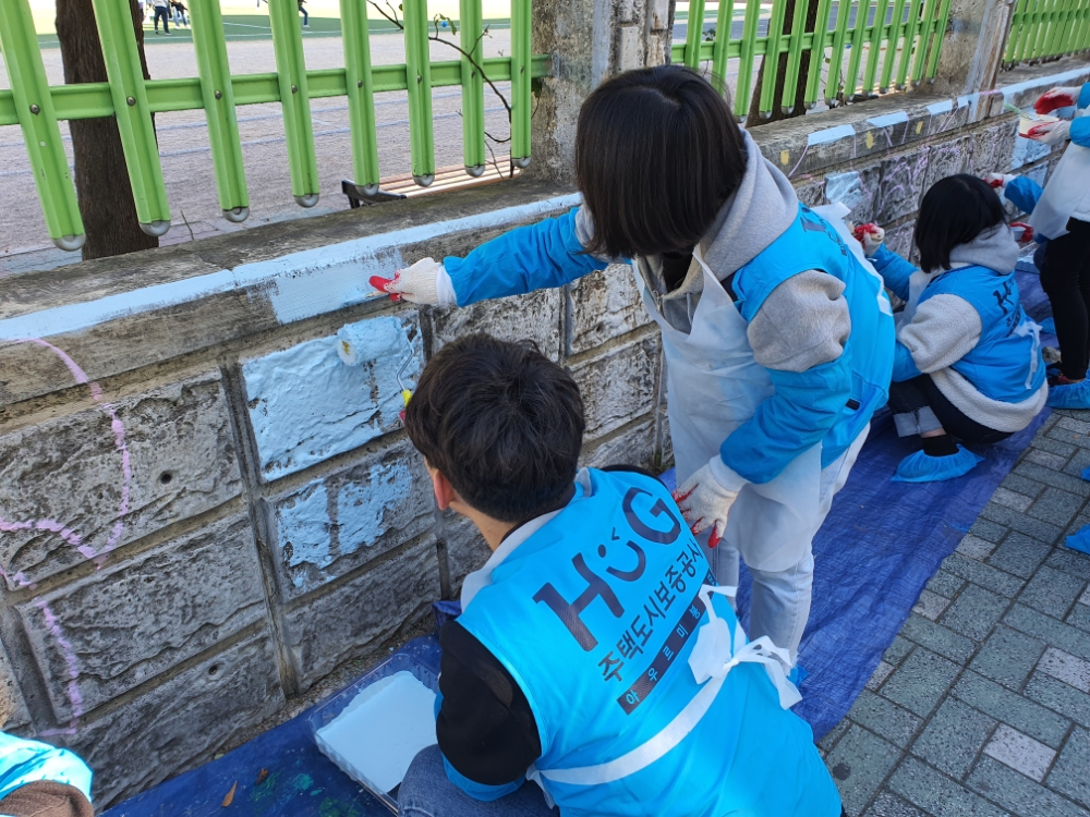 ‘벽화그리기’ 봉사활동에 참여한 HUG 임직원 및 대학생 봉사단이 벽화를 그리기 위해 페인트를 칠하고 있다.(사진=HUG)