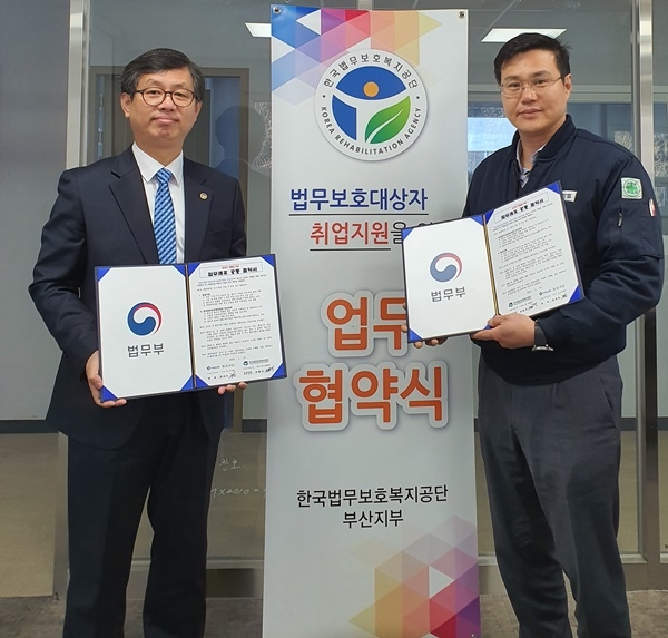 취업지원 업무협약서를 내보이며 기념촬영.(사진제공=한국법무보호복지공단부산지부)