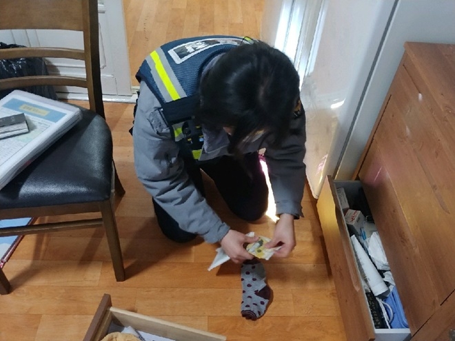양말에서 찾은 돈을 확인하고 있는 김새봄 순경.(사진제공=부산경찰청)