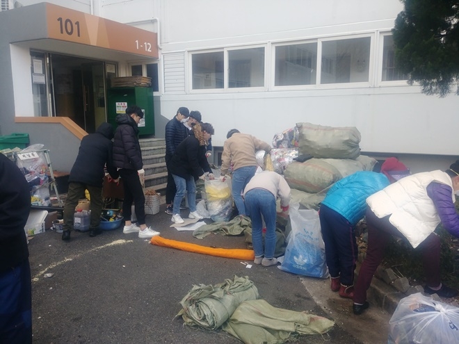 저장강박 가구의 적치물을 치우고 있다.(사진제공=부산서부준법지원센터)