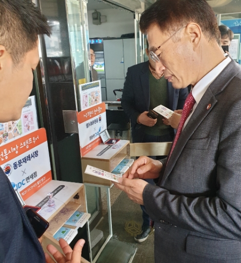 JDC 상생협력 실무자로부터 '전통시장 스탬프 투어' 관련 설명을 듣고 있는 문대림 JDC 이사장. 사진=JDC