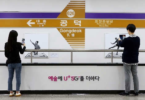 서울 지하철 6호선 공덕역에 마련된 세계 최초 5G기반 문화예술 공간 ’U+5G 갤러리’에 방문한 고객이 ‘U+AR’ 앱으로 작품을 체험하고 감상하는 모습. 사진=LG유플러스