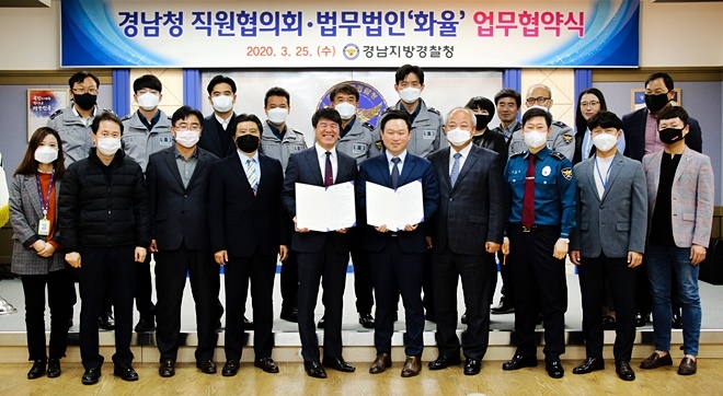 경남청 직원협의회와 법무법인 화율이 업무협약서를 내보이며 기념촬영.(사진제공=경남경찰청)