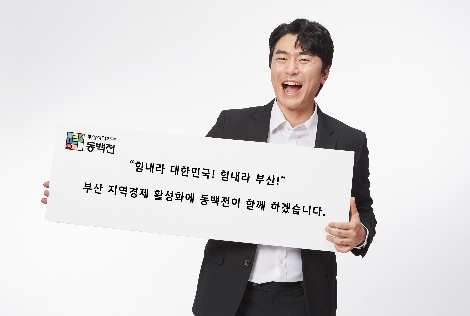 동백전 홍보모델인 배우 이시언이 부산 시민들을 응원하는 플래카드를 들고 있는 모습. 사진=KT