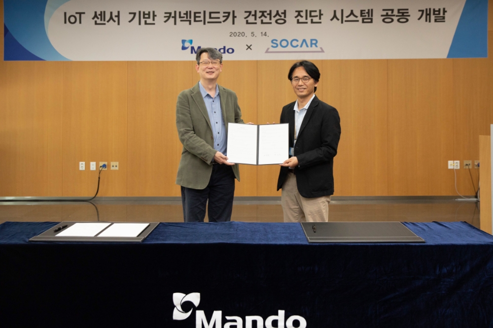 만도 F3랩 실장 박규식 상무(오른쪽)와 쏘카 원종필 기술총괄책임자(왼쪽)가 14일 판교 만도 글로벌 R&D 센터에서 'IoT 센서 기반 커넥티드카 건전성 진단 시스템 공동 개발 MOU' 체결 후 기념 촬영을 하고 있다.