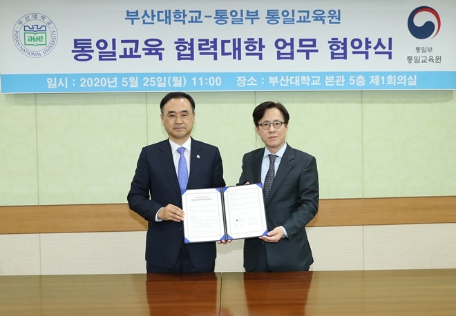25일 오전 11시 부산대 본관 5층 회의실에서 차정인 부산대 총장(사진왼쪽)과 백준기 통일부 통일교육원장이 업무협약서를 내보이며 기념촬영.(사진제공=부산대)