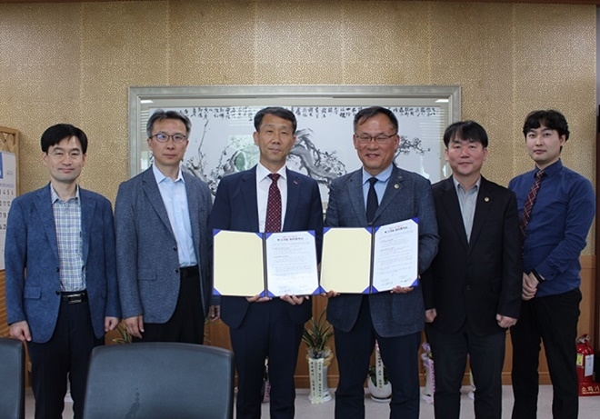 정봉영 지부장(사진우측세번째)과 황명욱 본부장이 협약서를 내보이며 직원들과 기념촬영.(사진제공=한국법무보호복지공단경남지부)