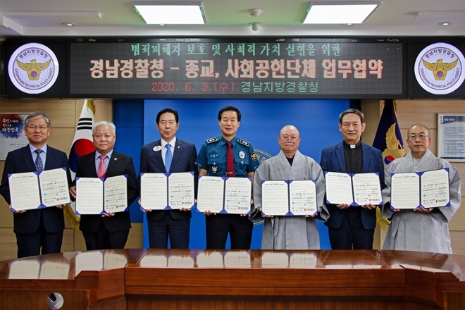 업무협약서를 내보이며 기념촬영.(사진제공=경남경찰청)