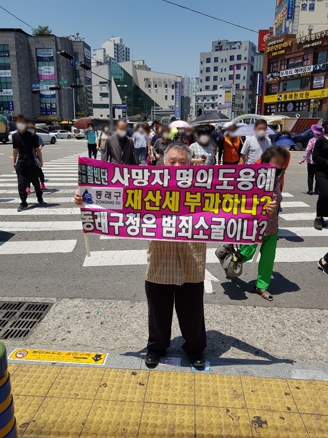 동래지하철 역 인근 횡단보도에서 1인 시위를 하고 있다.