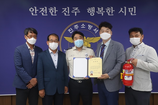김홍찬 진주소방서장이 심폐소생술로 승객 생명 구한 버스기사김경덕씨에게 표창을 수여하고 기념촬영.(사진제공=진주소방서)