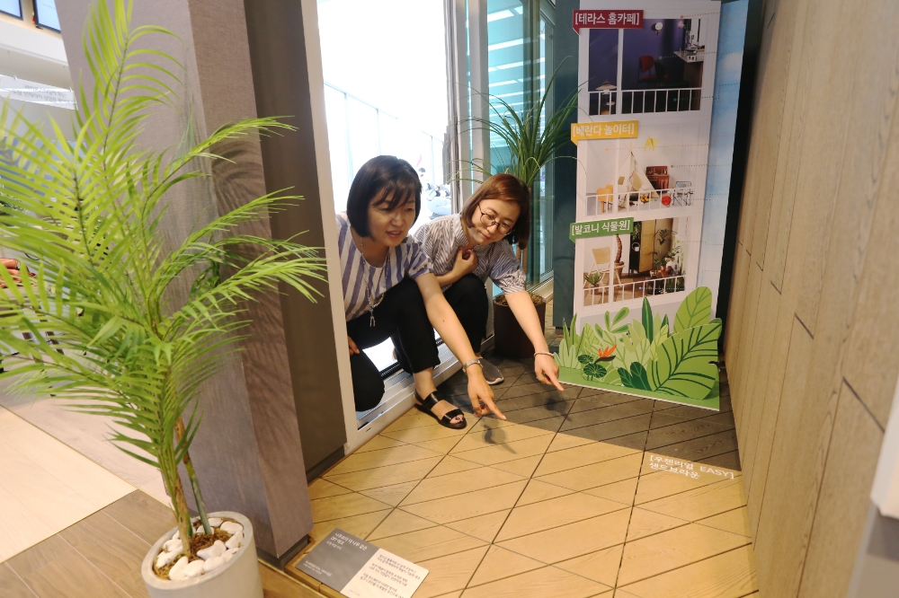 서울 강서구 LG전자 베스트샵 내에 위치한 LG지인 인테리어 매장을 방문한 고객이 LG하우시스의 데크 바닥재 등으로 꾸며진 '식물원 패키지' 발코니 공간을 살펴보고 있는 모습.(사진=LG하우시스)