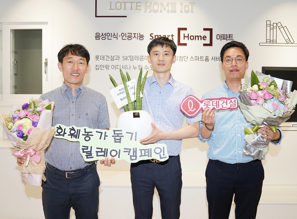 롯데건설 대구 C/S센터 근무자들이 꽃다발과 공기정화 식물이 담긴 화분을 들고 사진을 찍고 있다.(사진=롯데건설)