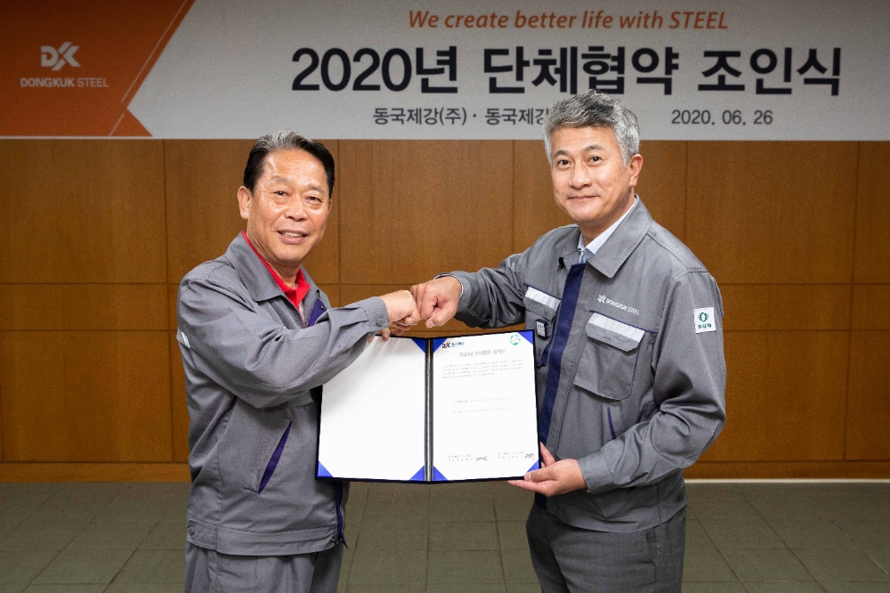 (오른쪽) 장세욱 동국제강 부회장과 박상규 노조위원장이 합의서를 들고 주먹 인사를 나누고 있다.(사진=동국제강)