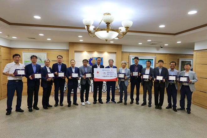(가운데 전달판) 왼쪽부터 경남사회복지공동모금회 강기철 회장, 창원상공회의소 손무곤 사무처장 외 창원상공회의소 간부 직원 12명 .(사진제공=경남사랑의열매)