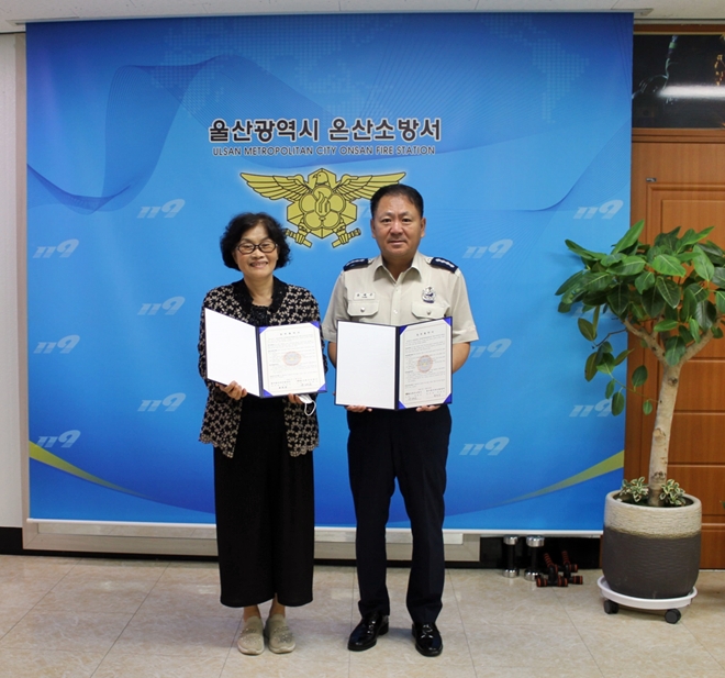 윤태곤 서장이 꿈자랑지역아동센터와 업무협약을 맺고 협약서를 내보이며 기념촬영.(사진제공=울산온산소방서)