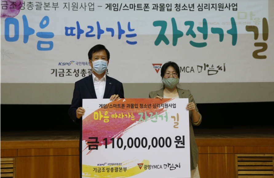 김광식 경륜경정관리본부장(왼쪽)이 광명YMCA 강옥희 사무총장에게 게임/스마트폰 과몰입 청소년 심리지원사업 「마음 따라가는 자전거 길」에 지원금을 전달했다. (사진=국민체육진흥공단)