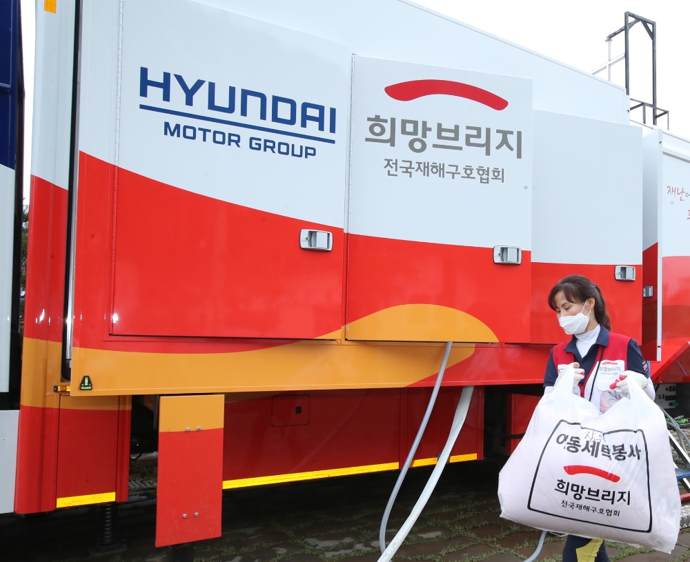 최근 폭우와 침수로 피해를 입은 경북 영덕군 강구면 강구시장에서 현대차그룹의 세탁구호차량과 함께 희망브리지 전국재해구호협회 자원봉사자들이 세탁 봉사활동을 하고 있는 모습.(사진=현대자동차그룹)