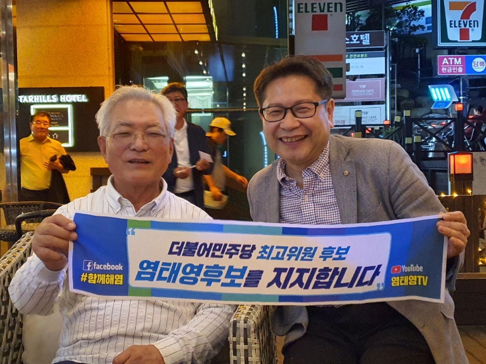 강민구 염태영캠프 조직본부장과 함께 염태영후보 응원피켓을 들고 있는 송기인 신부