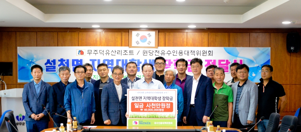 부영그룹 무주덕유산리조트 임직원이 원당천유수인용대책위원회 이강전 위원장에게 저소득가구 대학생 장학금을 전달하는 모습.(사진=부영그룹)