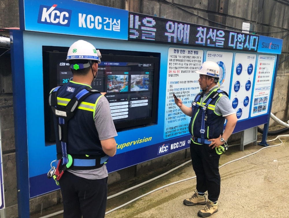 KCC건설 공사현장에서 직원들이 DID(digital information display)를 통해 위험요인, 유해요인 등 현장내 각종 정보를 확인하고 있는 모습.(사진=KCC건설)