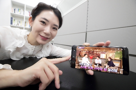 모델이 스마트폰을 통해 AI Study Week에서 제공하는 AI 학습 영상을 시청하고 있다. 사진=KT