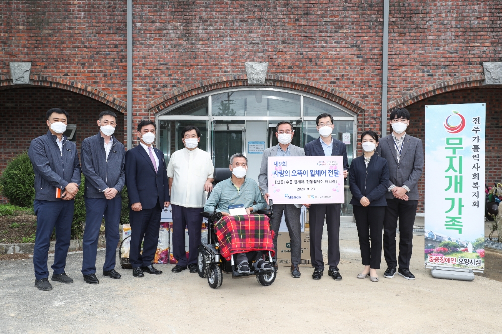 한국교통안전공단 교통복지처 김경식 처장(왼쪽부터 일곱 번째)과 ㈜만도 글로벌 서스팬션부 오퍼레이션 센터장 김구현 상무(왼쪽부터 세 번째)는 함께 오뚝이 휠체어 선정자를 방문하여 휠체어를 전달하고 있다.(사진=한국교통안전공단)
