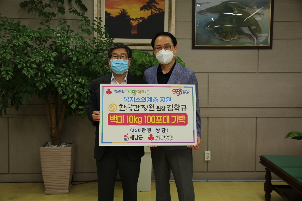 한국감정원 홍보실 남형우 실장(사진 우측)이 추석맞이 사랑의 쌀을 후원한 후 해남군청 강상구 부군수와 사진촬영을 하고 있다.(사진=한국감정원)