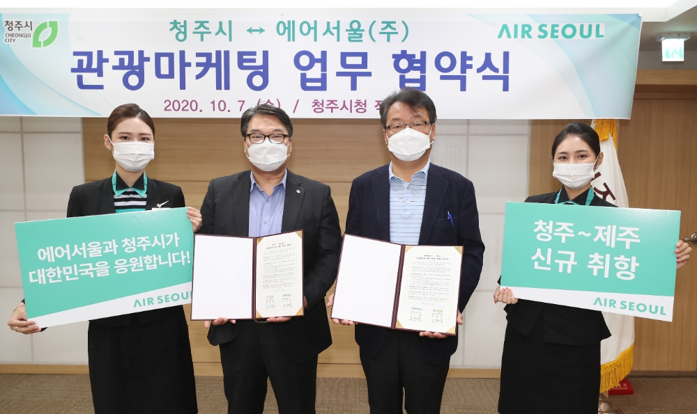 에어서울과 청주시가 청주~제주 첫 취항을 맞아 '관광 협력 협약'을 체결하고 기념사진 촬영을 하고 있다.(왼쪽부터 에어서울 캐빈승무원, 에어서울 조진만 경영본부장, 김항섭 청주시 부시장, 에어서울 캐빈승무원)