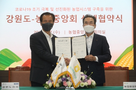 이성희 농협중앙회장(오른쪽)과 최문순 강원도지사(왼쪽)가 상생협약서에 서명한 뒤 기념촬영을 하고 있다. 사진=농협중앙회