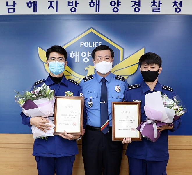 27일 구자영 남해해경청장과 팬더헬기 교관조종사로 임명된 부산항공대 최홍준 경위(왼쪽)와 이종선 경위(오른쪽)가 기념촬영을 하고 있다.(사진제공=남해지방해양경찰청)