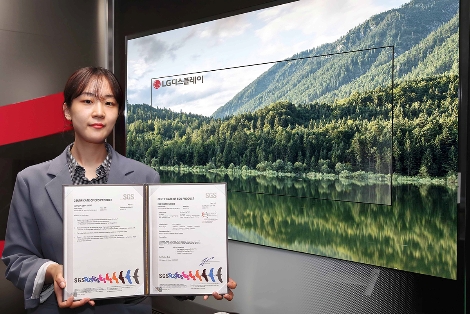 LG디스플레이 직원이 OLED TV 앞에서 SGS 인증서를 들고있는 모습. 사진=LG디스플레이