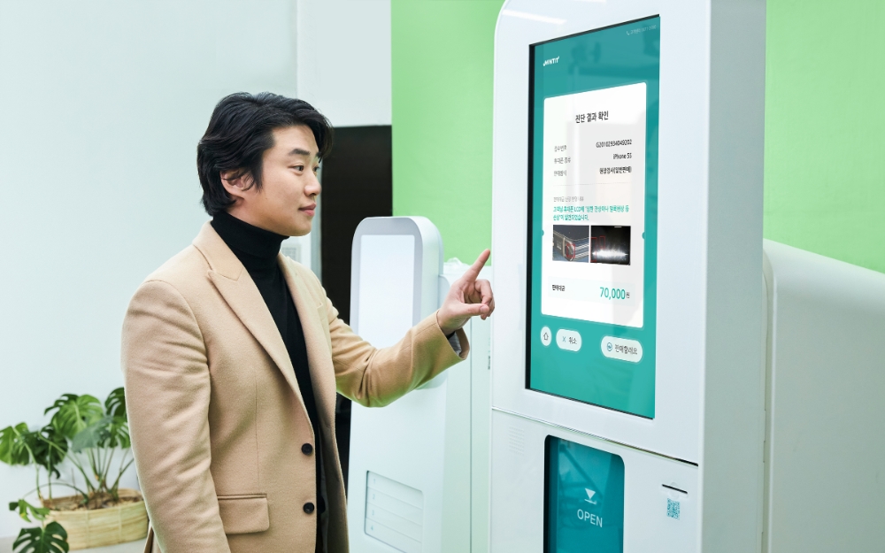 민팃ATM 모델인 안재홍이 휴대폰 검사결과 기능을 이용하고 있다.(사진=SK네트웍스)