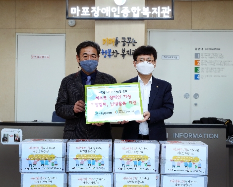 저축은행중앙회 조정연(우측) 상무와 마포장애인복지관 김명규(좌측) 사무국장이 9일 '저소득 장애인 가정을 위한 김장김치와 난방용품 지원' 행사를 마친 후 기념촬영을 하고 있다. 사진=저축은행중앙회