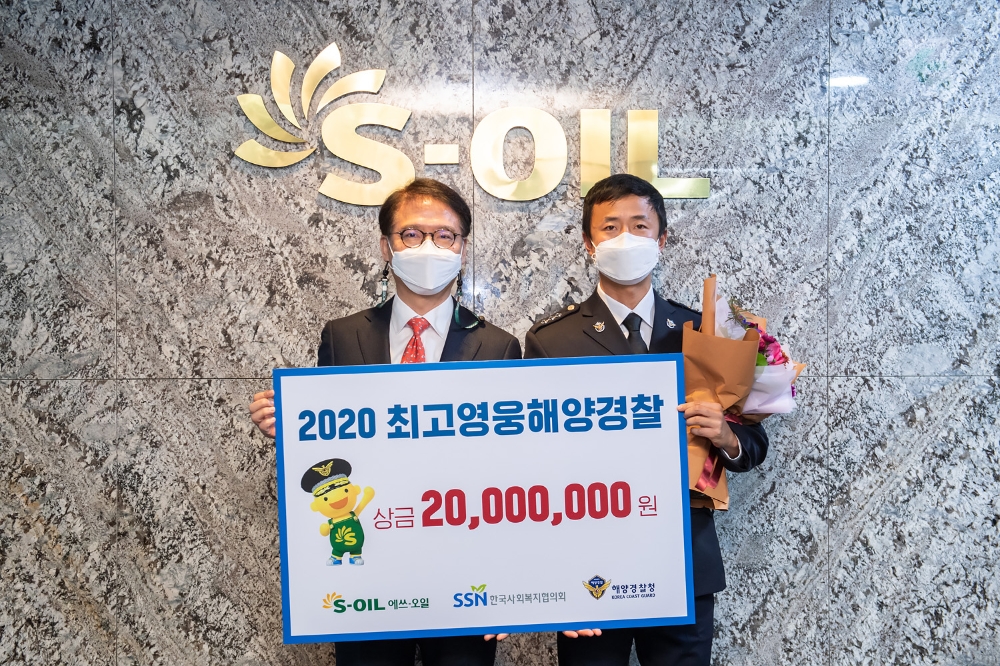 에쓰오일 류열 사장(왼쪽)이 통영해양경찰서 정용수 경장에게 “올해의 최고영웅 해양경찰” 상패와 상금을 전달하고 기념촬영을 하고 있다.(사진=에쓰오일)