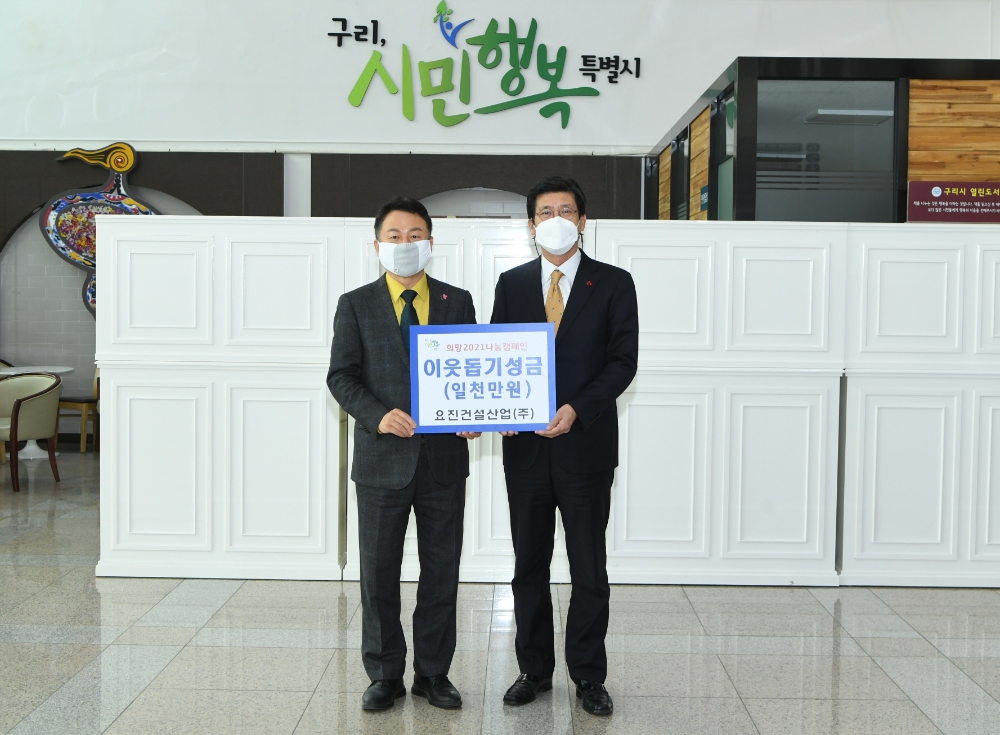 요진건설산업 이병호 상무(오른쪽)가 안승남 구리시장(왼쪽)에게 이웃 돕기 성금을 전달하고 있다.(사진=요진건설산업)