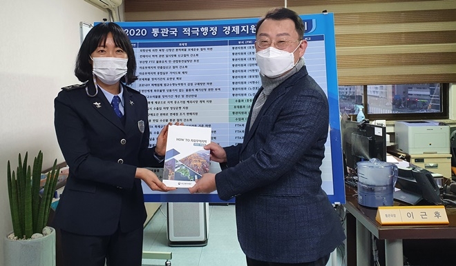 이근후 통관국장(오른쪽)과 이현정 관세행정관(왼쪽)이 가이드북을 들어보이고 있다.(사진제공=부산본부세관)
