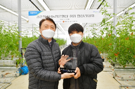 NH농협은행 권준학 은행장(좌측)이 5일 충남 아산시에 위치한 팜엔조이 농장을 방문한 후 박세근 대표(우측)와 기념촬영을 하고 있다. 사진=NH농협은행