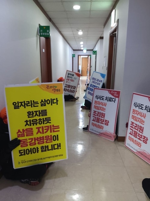 이사장실 앞에서 집단해고 철회 답변을 받고자 난방이 끊긴 복도에서 밤새워 대기하고 있는 조리원 조합원들.(사진제공=보건의료노조)