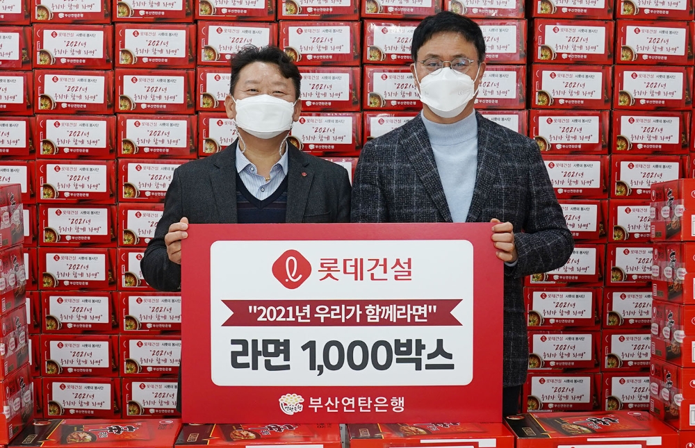 김재권 롯데건설 영남지사장(좌)과 강정칠 부산연탄은행 대표(우)이 사랑의 라면 나눔 기념 촬영 중이다.(사진=롯데건설)