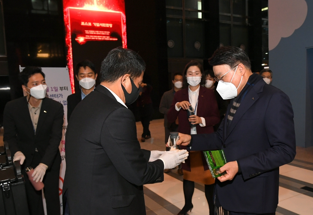 최정우 회장이 포스코센터 일회용 컵 사용 없는 시범빌딩 운영 첫날 열린 캠페인에서 텀블러에 커피를 제공받고 있다.(사진=포스코)