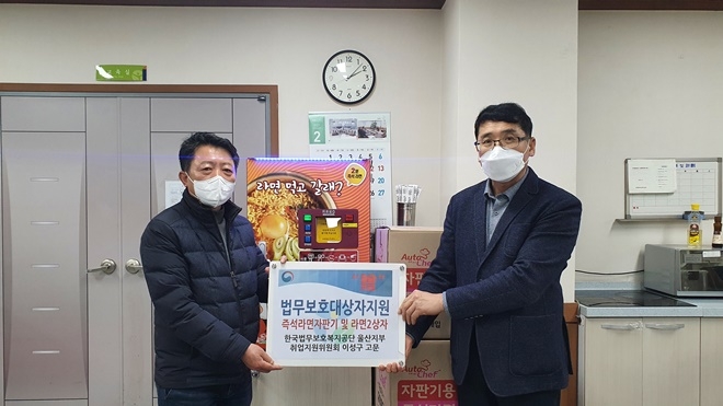 울산지부 취업지원위원회 이성구 고문(왼쪽)이 김주병 지부장에게 즉석라면자판기 등을 지원하고 기념촬영.(사진제공=한국법무보호복지공단울산지부)