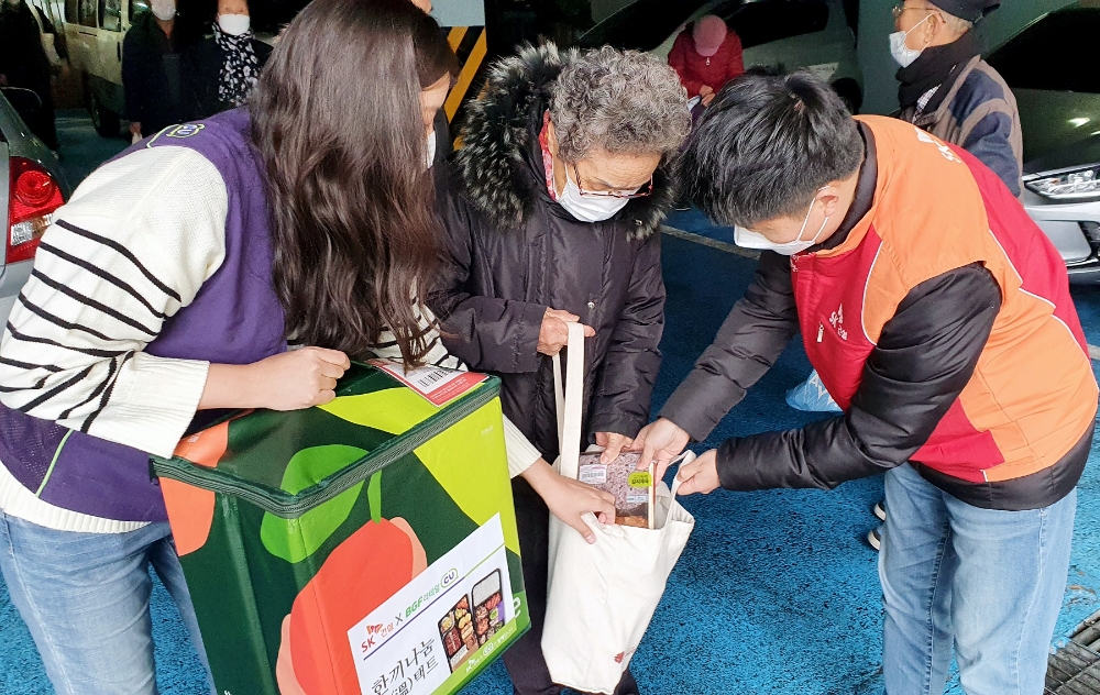 지난 2일 SK건설과 BGF리테일 구성원이 도시락을 어르신분께 전달하고 있는 모습.(사진=SK건설)