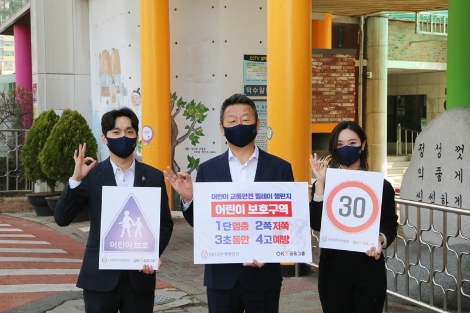 최윤 OK금융그룹 회장(사진 가운데)이 서울시 중구에 위치한 덕수초등학교 앞 어린이보호구역에서 임직원과 함께 어린이 교통 안전 표어를 들고 ‘어린이 교통안전 릴레이 챌린지’에 참여하고 있다. 사진=OK금융그룹