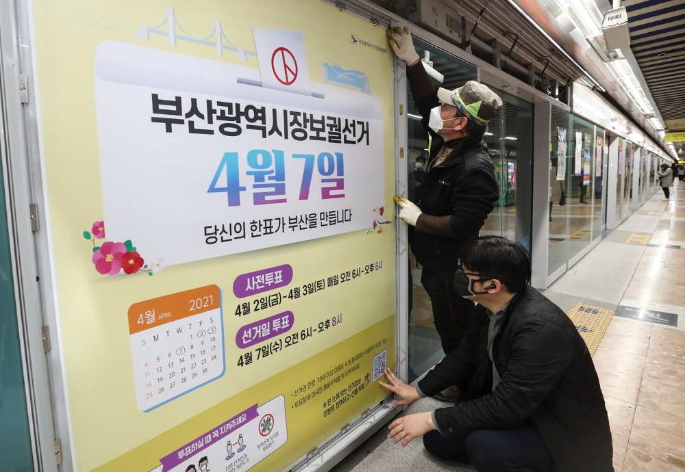 17일 오전 부산도시철도 1호선 시청역 승강장에서 부산시선관위 관계자들이 스크린도어에 부산시장 보궐선거 투표 참여 홍보물을 붙이고 있다.(사진제공=연합뉴스)