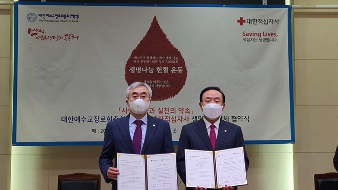 (사진왼쪽부터) 조남선 혈액관리본부장, 장종현 대한예수교장로회총회장이 업무협약서를 내보이며 기념촬영.(사진제공=대한적십자사)