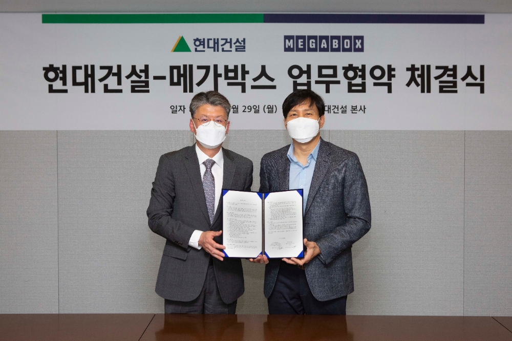 최재범 현대건설 주택사업본부장(사진 오른쪽)과 메가박스 김진선 대표(사진 왼쪽)가 협약서에 서명한 뒤 기념사진을 찍고 있다.(사진=현대건설)