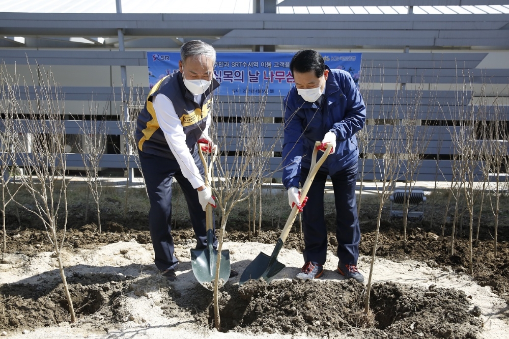 권태명 SR 대표이사(사진 오른쪽)가 5일(월) SRT 수서역에서 박찬일 KB국민은행 강동지역그룹 대표(사진 왼쪽)와 무궁화 묘목을 식재하며 제76회 식목일 행사를 진행하고 있다.(사진=SR)