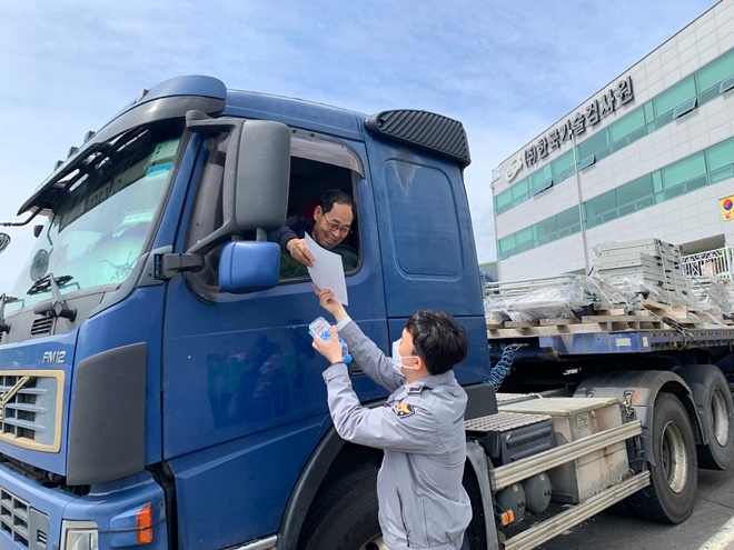 경찰이 졸음운전 예방을 위한 껌, 생수를 배부하고 졸음운전 예방수칙 홍보물을 건네며 안전운전을 당부하고 있다.(사진제공=창원서부경찰서)