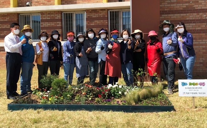 전주기전대학 허브조경과 최연우 교수와 지도 학생들이 24일 함께 전주소년원에 '행복 화단' 자원봉사를 하고 기념촬영.(사진제공=전주소년원)